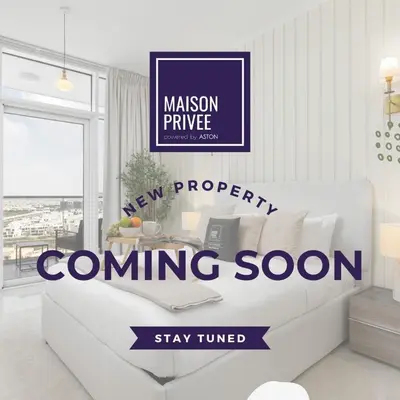 a living room with a white couch and a winning soon sign at Maison Privee - Urban Living with Dubai Marina Skyline Views in Dubai