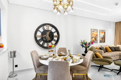 a dining room with a table and a clock on the wall at Enchanted 1BR Royal Amwaj Burj View & Private Beach in Dubai