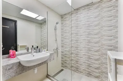 a bathroom with a sink and a glass shower at Chic Studio Near Circle Mall & Dubai Sports City in Dubai