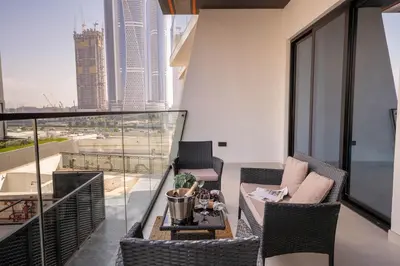 a balcony with chairs and a table on a building at Frank Porter - Binghatti Canal in Dubai