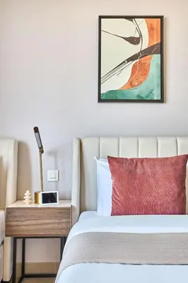 a bedroom with a bed and a table with a clock on it at Frank Porter - Sparkle Tower 1 in Dubai