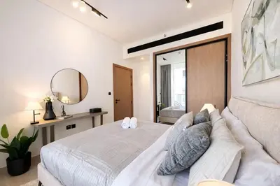 a bedroom with a large bed and a mirror at Refined Luxury 1BR Binghatti Azure in Dubai
