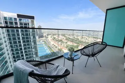 a balcony with two chairs and a table on a building at Refined Luxury 1BR Binghatti Azure in Dubai