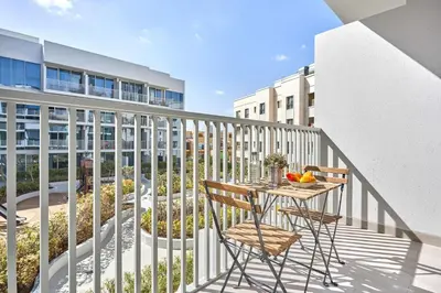 a balcony with a table and chairs and a building at Frank Porter - Luma 21 in Dubai