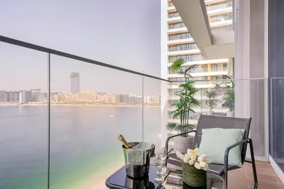 a balcony with a table and a chair and a view of the water at Frank Porter - Beach Isle, Emaar Beachfront in Dubai