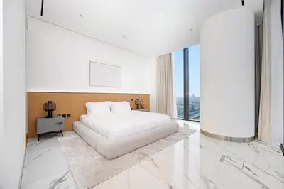a bedroom with a white bed and large windows at Stylish 4BR Penthouse with Maids Room & Modern Amenities in Dubai