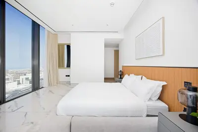 a bedroom with a white bed and a large window at Stylish 4BR Penthouse with Maids Room & Modern Amenities in Dubai
