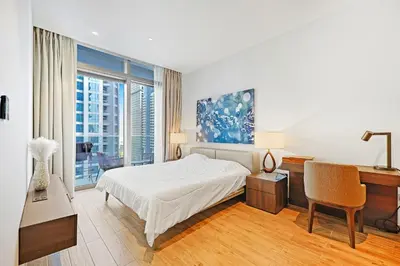 a white bedroom with a bed and a desk and a piano at Elegant 1-Bed Apartment with Premium Comforts in Dubai
