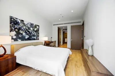 a bedroom with a white bed and a painting on the wall at Elegant 1-Bed Apartment with Premium Comforts in Dubai