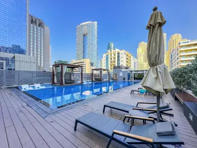 a rooftop pool with two chairs and an umbrella at StudioOne Tower Sky-High Marina Chic, Sea Views & Designer Pool in Dubai