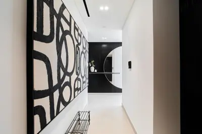 a hallway with black and white art on the wall at Elegant 2BR Apartment with Private Pool in JVC in Dubai