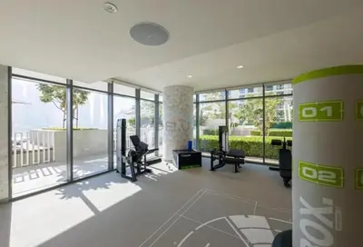 a large room with glass doors and chairs in a building at Prime Waterfront Living with Partial Sea Views, Just a Short Drive from Palm Jumeirah, Marina Vista Tower 1, Emaar Beachfront by Deluxe Holiday Homes in Dubai