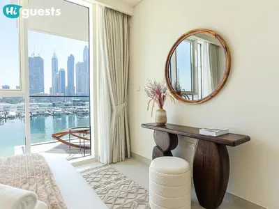 a bedroom with a large window and a mirror at HiGuests - Beautiful Sea Facing 1BR at Emaar Beachfront in Dubai