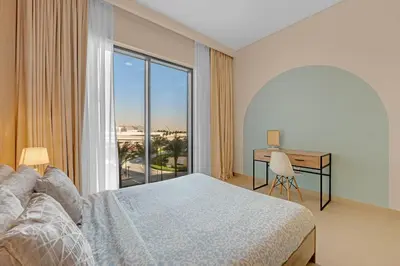 a bedroom with a bed and a desk and a window at Stylish Chic 1BR with Lagoons Access - Creek Beach in Dubai