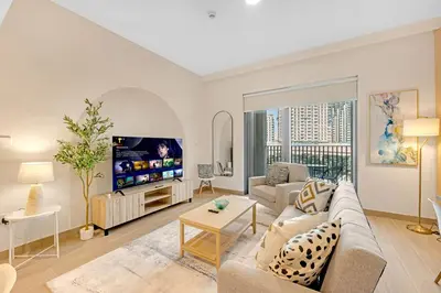 a living room with a couch and a tv at Stylish Chic 1BR with Lagoons Access - Creek Beach in Dubai