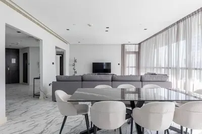 a dining room with a table and chairs and a couch at Penthouse Vibes 3BR Billiard & Air Hockey in Dubai
