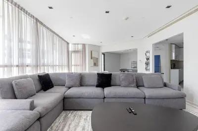 a living room with a couch and a table at Penthouse Vibes 3BR Billiard & Air Hockey in Dubai