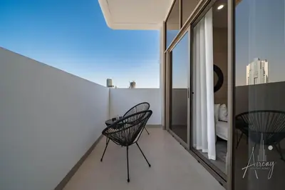 a balcony with two chairs and a view of the city at Sweet Escape 1BR in JVC Near Circle Mall in Dubai