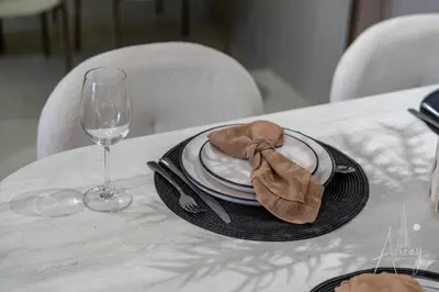 a plate with a napkin on a table with a glass at Sweet Escape 1BR in JVC Near Circle Mall in Dubai