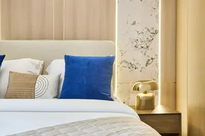 a bedroom with a bed with blue and white pillows at Modern 2BR Apartment at Grove 5 - Creek Beach & Pool Access in Dubai