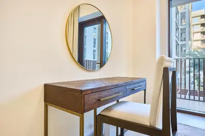 a dressing table with a mirror and a chair at Modern 2BR Apartment at Grove 5 - Creek Beach & Pool Access in Dubai