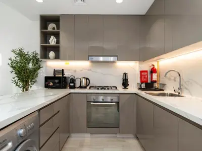 a kitchen with stainless steel appliances and white cabinets at Stunning 2BR at Azizi Amber Sleeps 5 in Dubai