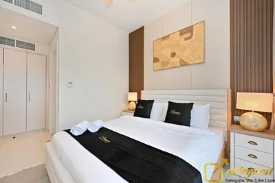 a bedroom with a large white bed with black pillows at Signature 3BR Maid Villa DH2 by Deleguest in Dubai