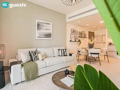 a living room with a couch and a table at HiGuests - Sunlit 1 BR Escape with Emaar Beachfront Access in Dubai