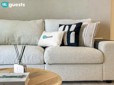a living room with a couch with pillows on it at HiGuests - Sunlit 1 BR Escape with Emaar Beachfront Access in Dubai