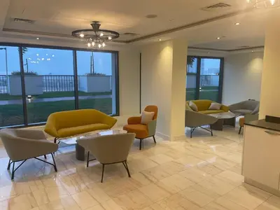 a waiting room with couches and tables and windows at Studio in Liwan for long stays 1005 in Dubai