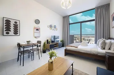 a bedroom with a bed and a table and a dining room at New studio in Arjan ideal for long stays in Dubai