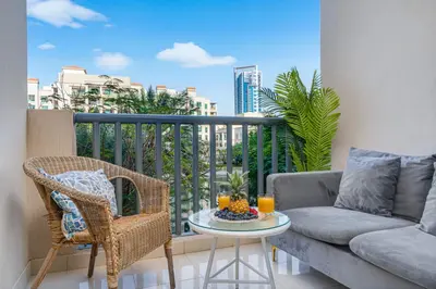 a living room with a couch and a table on a balcony at Serene Studio at The Links Canal in Dubai