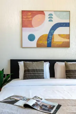 a bedroom with a bed with a painting on the wall at Modern Studio in Barsha south with balcony in Dubai