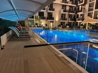 a swimming pool in front of a building at Modern Studio in Barsha south with balcony in Dubai