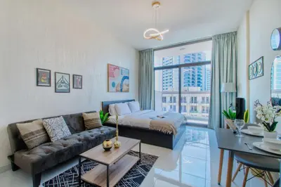 a living room with a couch and a bed at Modern Studio in Barsha south with balcony in Dubai