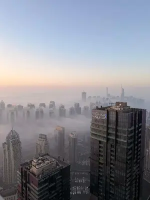 a foggy city skyline with tall buildings in the foreground at 77 Floor Luxury 1Br Marina Sea View Balcony in Dubai