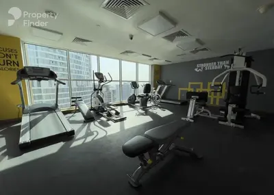 a gym with treadmills and exercise equipment in a building at Large 1-bedroom by the canal, close to downtown in Dubai
