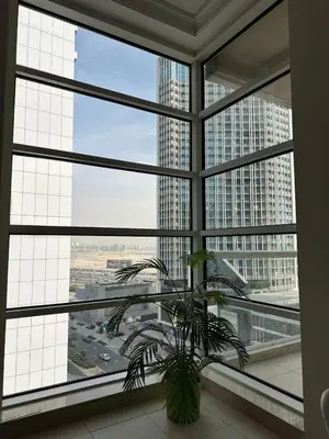 a plant in a room with a large window at Large 1-bedroom by the canal, close to downtown in Dubai