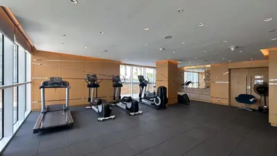 a gym with treadmills and exercise equipment in a building at Maison Privee - Refined Studio with Top Facilities in Damac Hills in Dubai