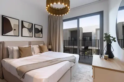 a bedroom with a large bed and a balcony at Spacious 3BR Villa plus Maids with Resort-Style Amenities in Tilal Al Ghaf in Dubai