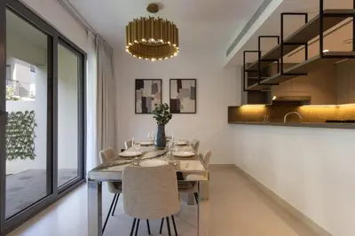 a dining room with a long table and chairs at Spacious 3BR Villa plus Maids with Resort-Style Amenities in Tilal Al Ghaf in Dubai