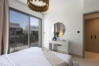 a bedroom with a bed and a mirror and a balcony at Spacious 3BR Villa plus Maids with Resort-Style Amenities in Tilal Al Ghaf in Dubai
