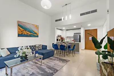 a living room with a blue couch and a table at The Smart Concierge - Andalus Jumeirah Golf Estates in Dubai
