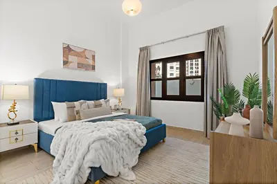 a bedroom with a blue bed and a window at The Smart Concierge - Andalus Jumeirah Golf Estates in Dubai