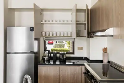 a kitchen with a stainless steel refrigerator at Family Retreat 3BR Greenwoods Villa in DAMAC Hills in Dubai