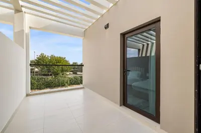 a room with a large glass door and a balcony at Family Retreat 3BR Greenwoods Villa in DAMAC Hills in Dubai