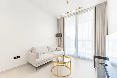 a white living room with a couch and a table at HAVN - 3 bedroom in Binghatti Crest, JVC in Dubai