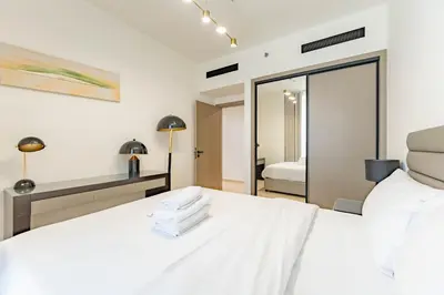 a bedroom with a white bed and a mirror at HAVN - 3 bedroom in Binghatti Crest, JVC in Dubai