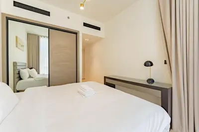 a bedroom with a white bed and a mirror at HAVN - 3 bedroom in Binghatti Crest, JVC in Dubai