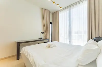 a bedroom with a white bed and a large window at HAVN - 3 bedroom in Binghatti Crest, JVC in Dubai